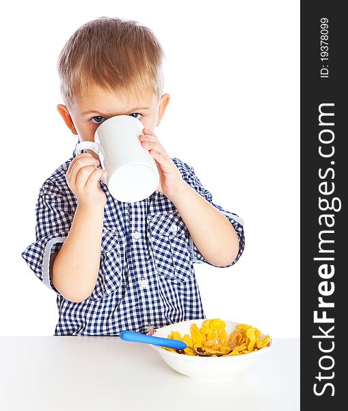 A boy is drinking milk and eating cereal from a bowl. Isolated on a white background. A boy is drinking milk and eating cereal from a bowl. Isolated on a white background