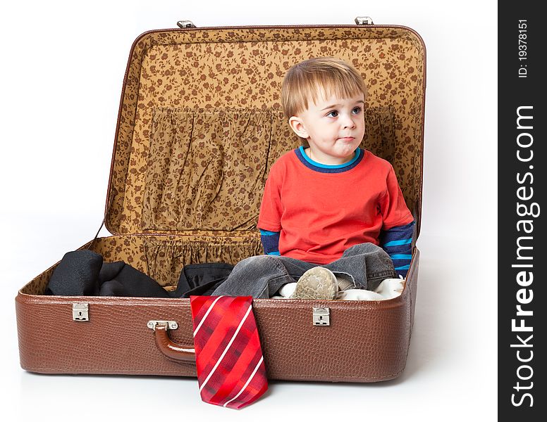 A funny boy in a suitcase. Isolated on a white background