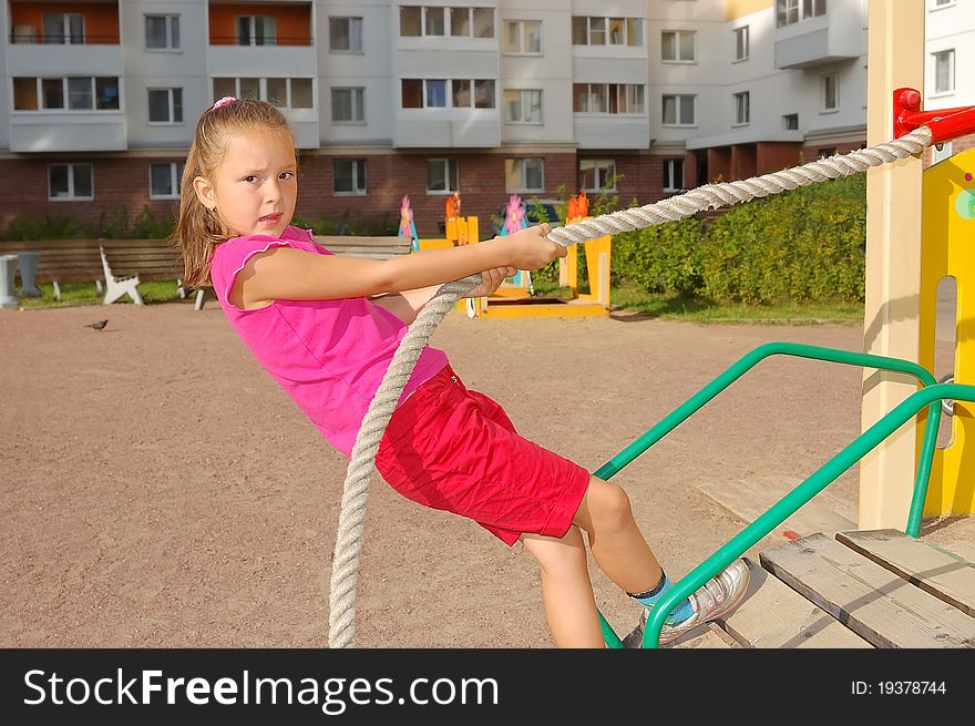 Girl keeps for a rope on a children's playground