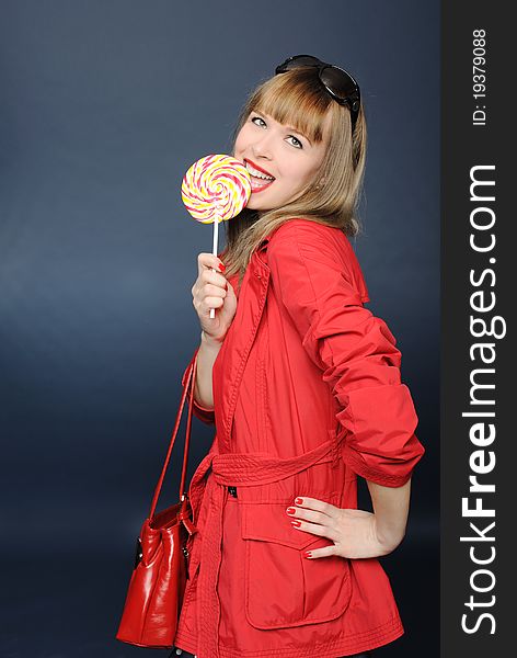 Pretty girl in red cloak holding a lollipop. Pretty girl in red cloak holding a lollipop