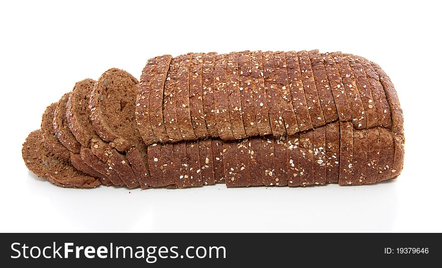 A sliced brown wholemeal bread with seeds isolated over white background