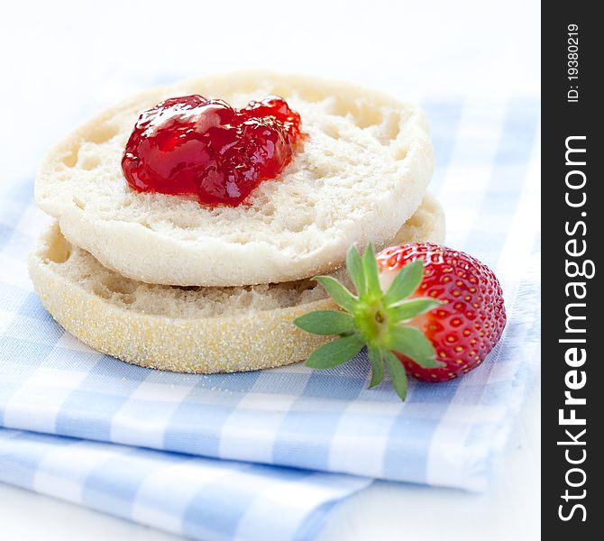 English muffin with jam on napkin