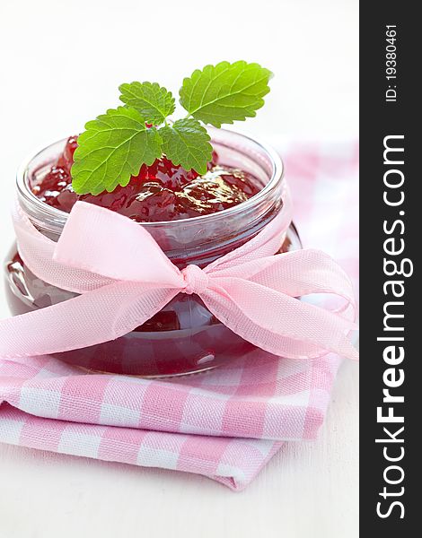 Fresh strawberry jam in a jar with ribbon