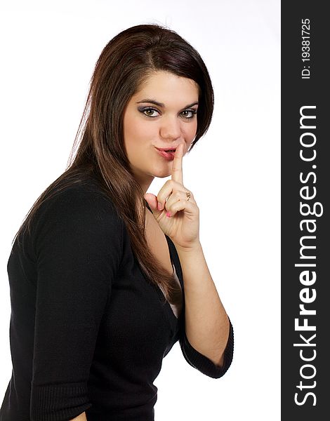 Young woman making a quiet gesture with index finger to her mouth