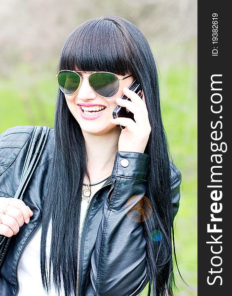 Single beautiful woman wearing sunglasses with cell phone outdoor. Single beautiful woman wearing sunglasses with cell phone outdoor
