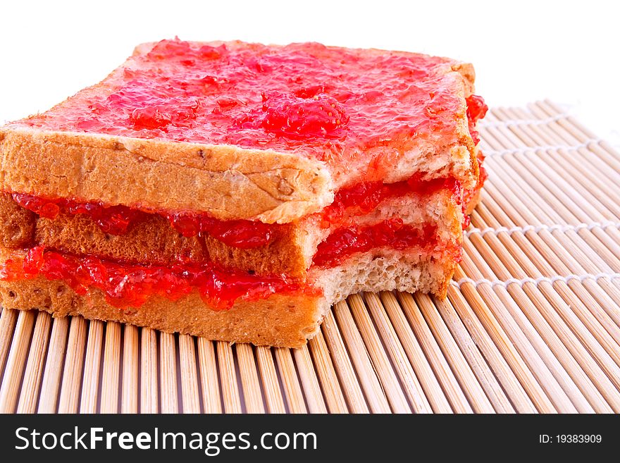 Whole wheat bread with strawberry jam on mat
