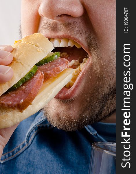 The man greedily eats a sandwich closeup. The man greedily eats a sandwich closeup