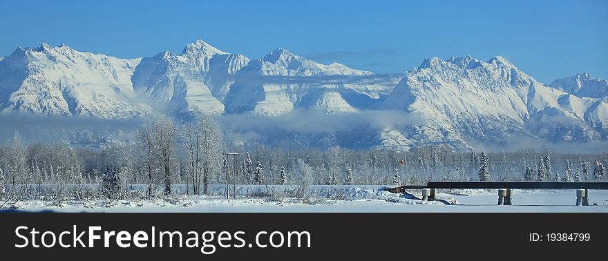 Railroad over frozen river into the Alaskan mountains. Railroad over frozen river into the Alaskan mountains
