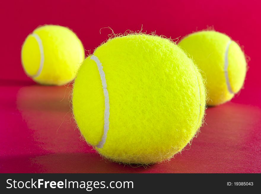 Three tennis balls on red