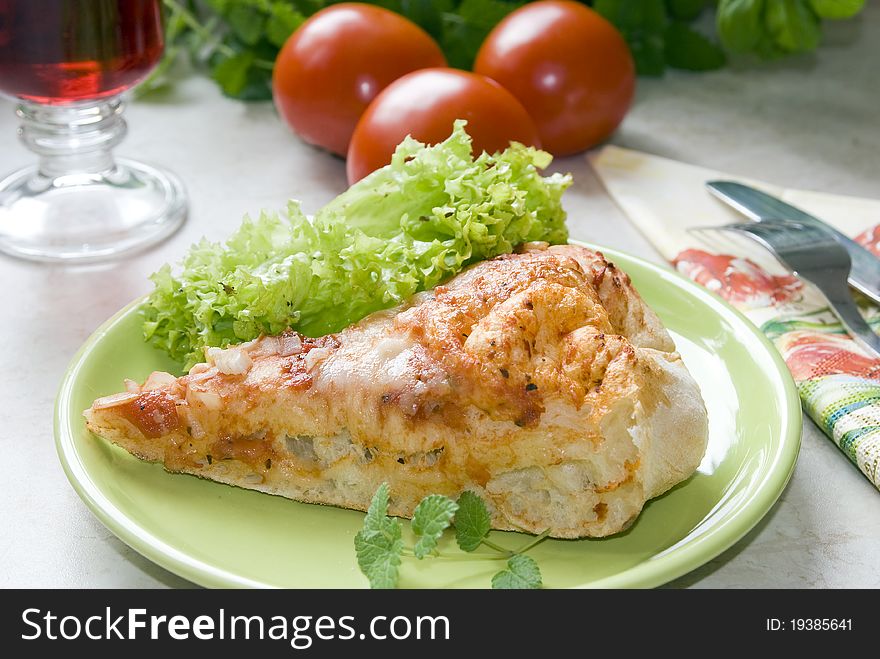 Tasty piece of pizza on a plate next to the fresh tomatoes. Tasty piece of pizza on a plate next to the fresh tomatoes