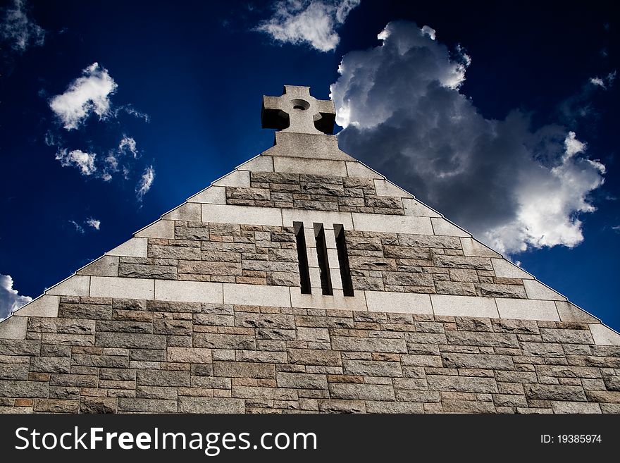 Top of roman style church against at deep and dark blue sky with clouds. Top of roman style church against at deep and dark blue sky with clouds.