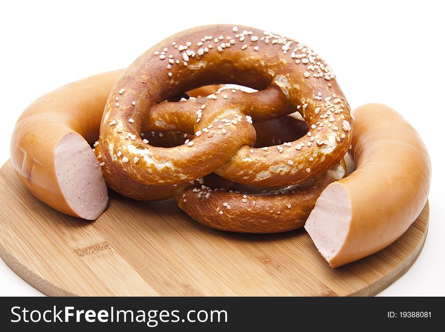 Meat sausage with salt pretzel onto wood plates