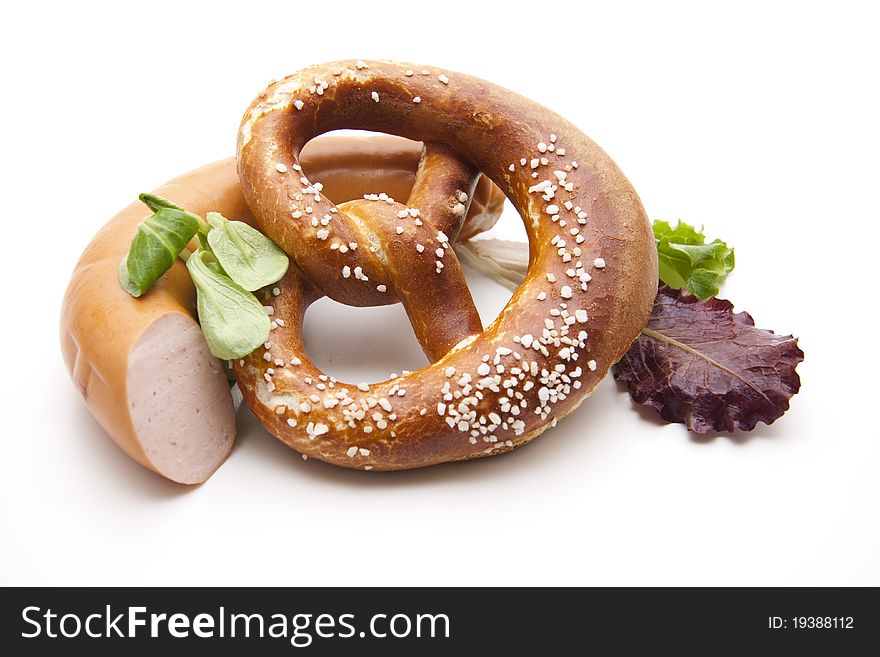 Meat sausage with salt pretzel and lettuce leaf