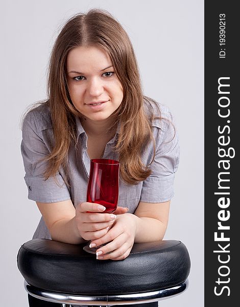 A Girl In A Bright Red T-shirt And A Glass Sitting