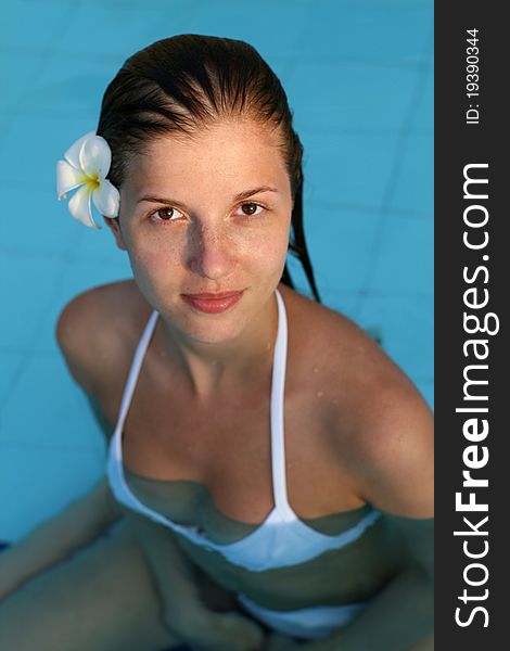 Young woman in swimming pool with flower in hairs. Young woman in swimming pool with flower in hairs