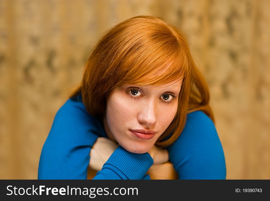 Young girl with red hair and sad eyes looking at us. Young girl with red hair and sad eyes looking at us