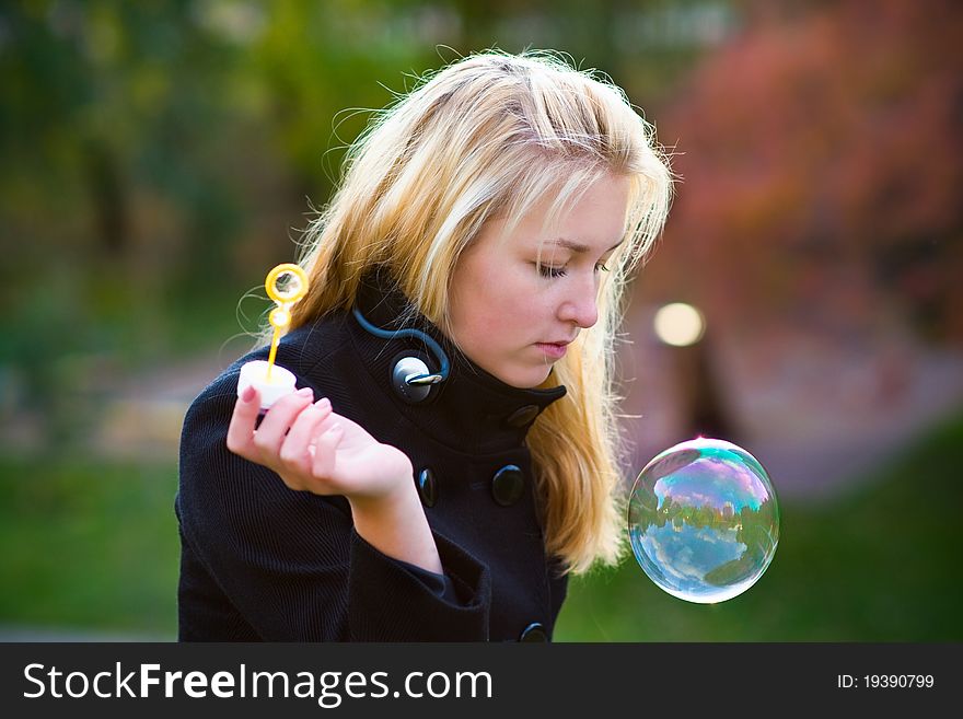 Teen girl looking at a large multi-colored bubbles, which gradually descends. Teen girl looking at a large multi-colored bubbles, which gradually descends