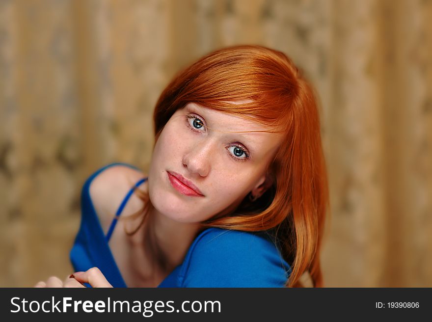 Young girl with red hair and sad eyes looking at us. Young girl with red hair and sad eyes looking at us