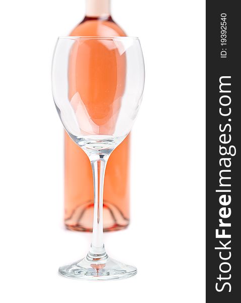 Rose wine in unmarked bottle with an empty glass in focus