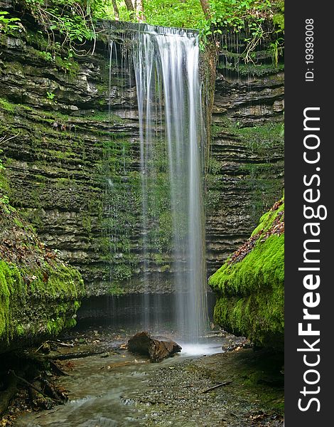 A gentle waterfall in a moss covered alcove. A gentle waterfall in a moss covered alcove