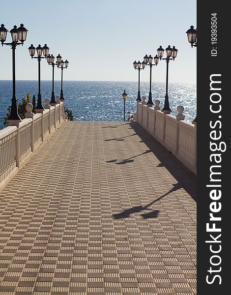 Walkway to the sea with lamp posts