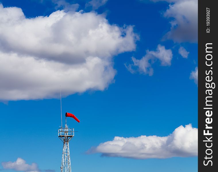 Bright Windsock Against a Vivid Blue Sky and Fluffy White Clouds