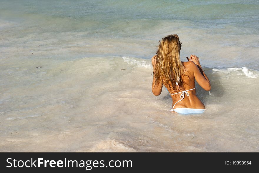 Beautiful woman in bikini going in the sea