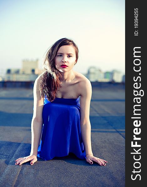 Attractive girl sitting in a blue dress