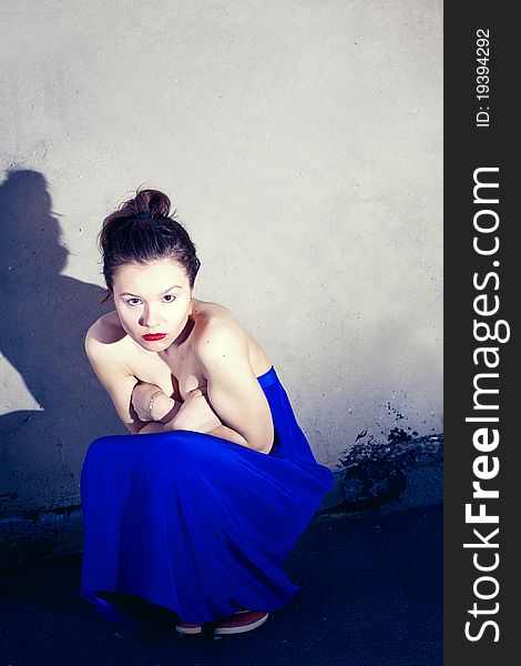 Glamour type photo of cute brunette sitting on the city bridge