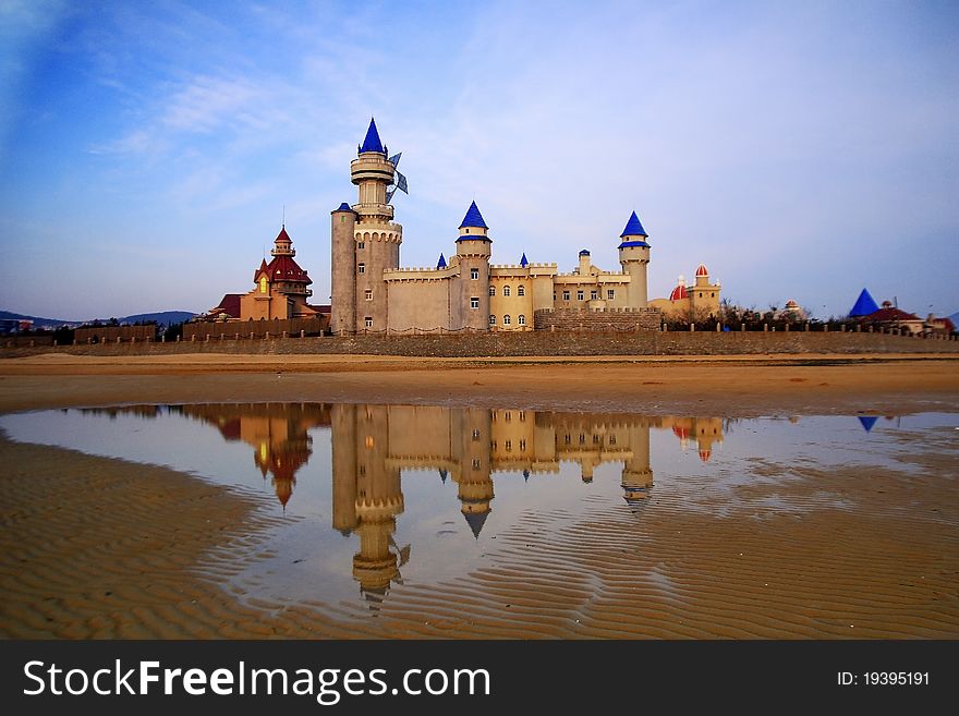 Shooting base of CCTV's colomn big pinwheel, set of castles on the beach with reflection. Shooting base of CCTV's colomn big pinwheel, set of castles on the beach with reflection