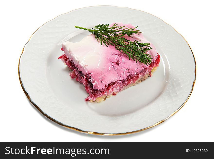 Layered salad of herring, potatoes, beets and mayonnaise on plate isolated on white background