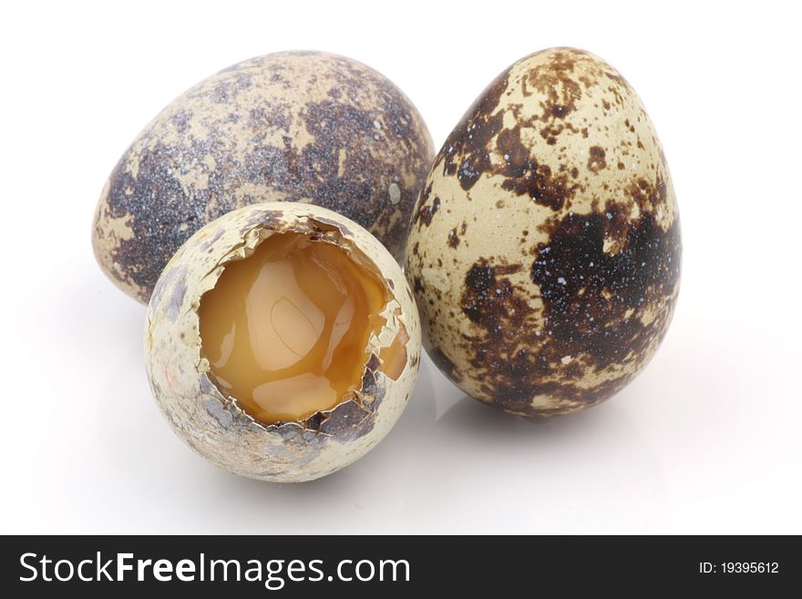 Isolated broken partridge egg in white background