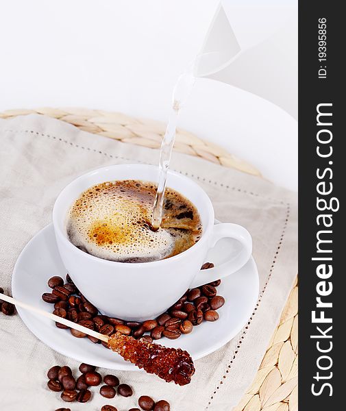 Coffee cup with sugar stick and beans