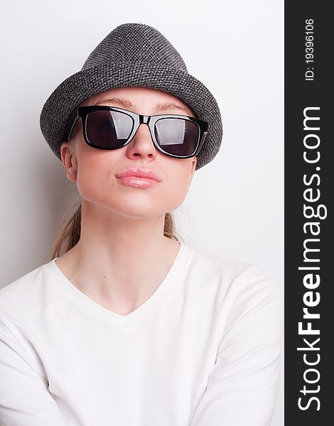 Retro photo of a girl in sunglasses and an old hat