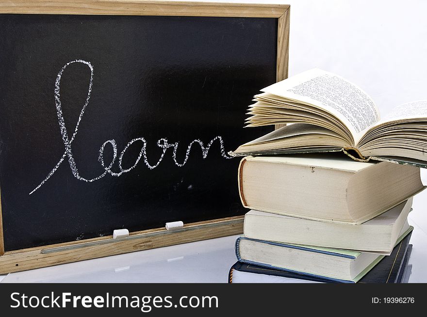 Word learn handwriting on a blackboard with books