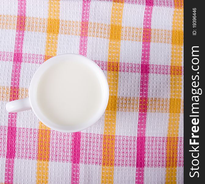 Mug of milk on a checkered tablecloth