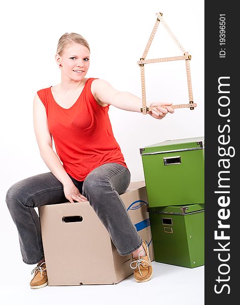 Young Woman With A House Symbol Sits On Moving Box