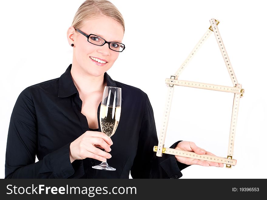 A young woman with folding rule as a house symbol and a champagne glass. A young woman with folding rule as a house symbol and a champagne glass