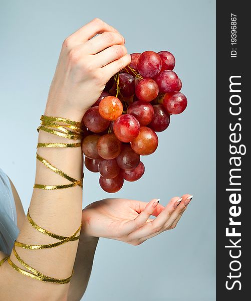 Bunch of grapes in the hands of a young woman