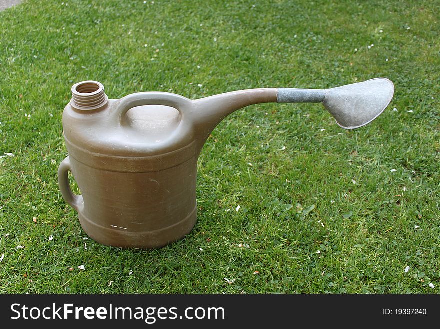 Watering can lying in the grass in spring. Watering can lying in the grass in spring