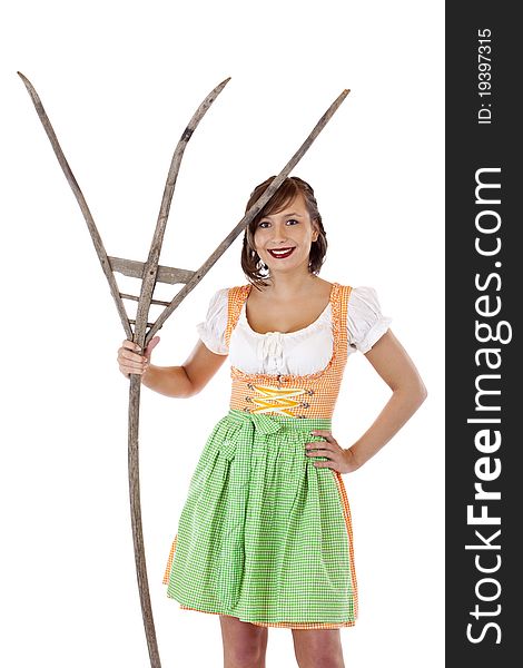 Beautiful woman with dirndl holds pitchfork