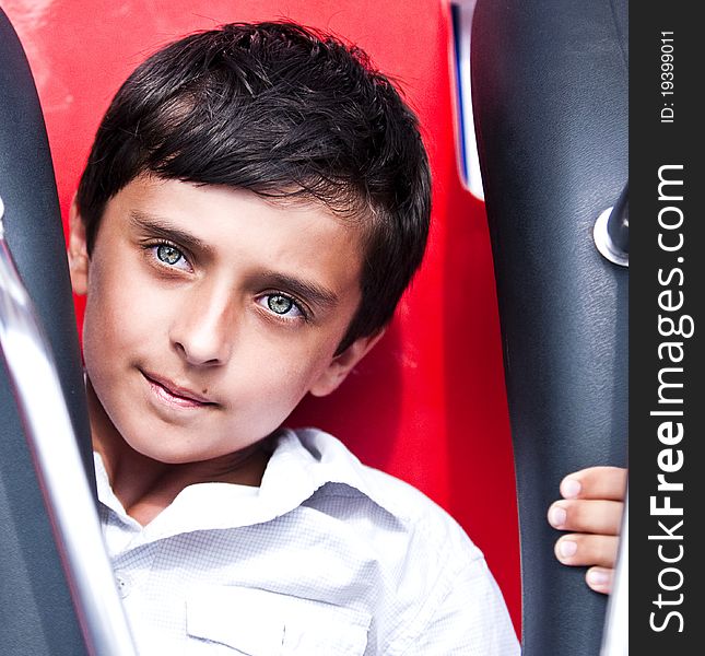 The boy in park goes for a drive on a roundabout