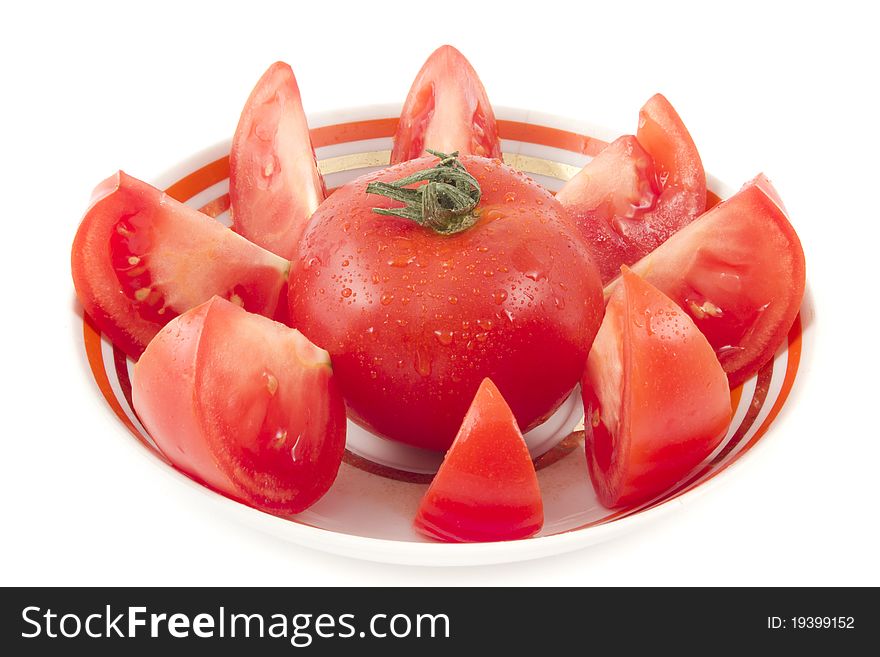 Fresh tomato on a plate. Around cut segments.