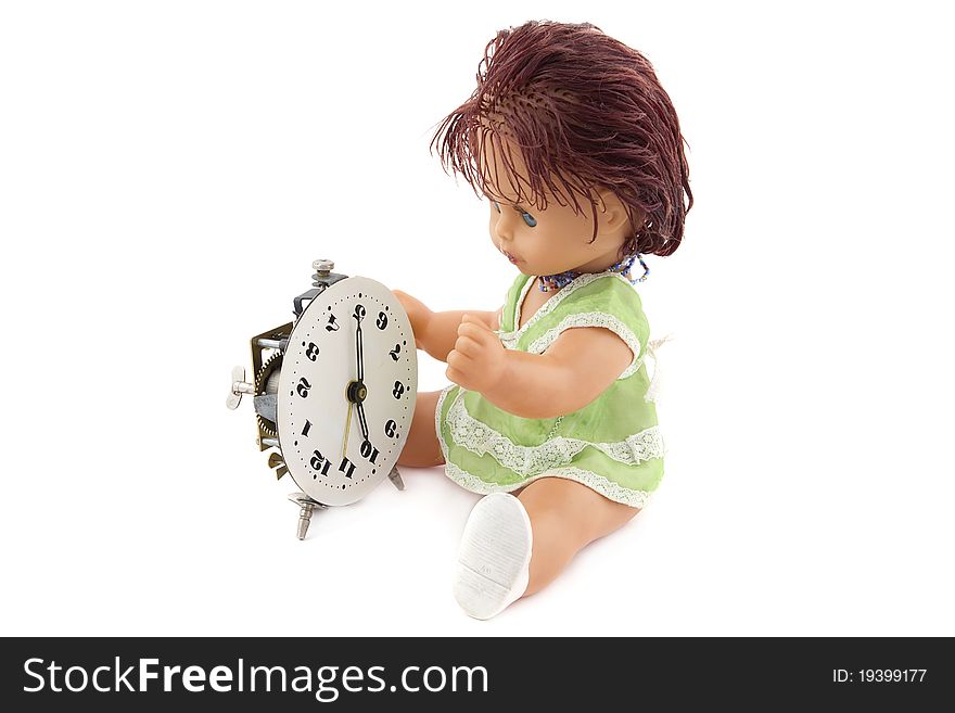 The doll repairing an ancient alarm clock. It is isolated on a white background.