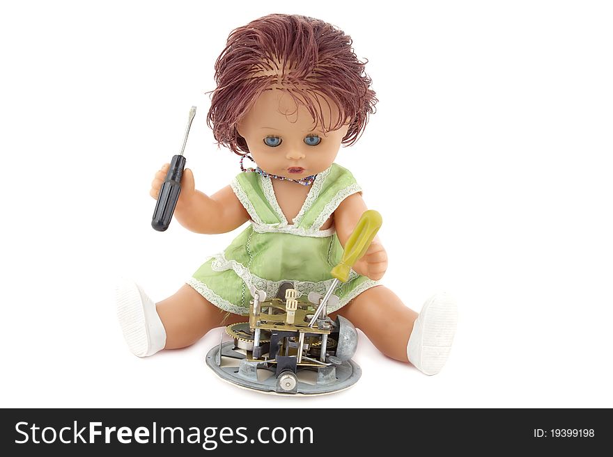 The doll repairing an ancient alarm clock. It is isolated on a white background.