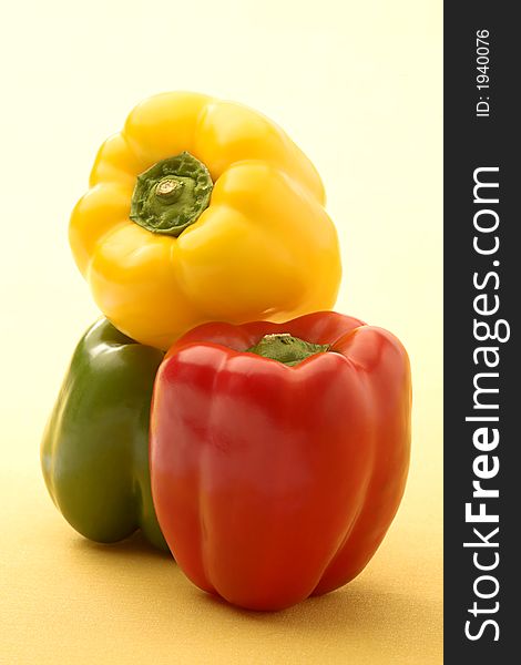 Red, green and yellow pepper on a yellow background. Red, green and yellow pepper on a yellow background