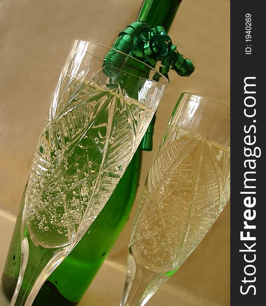 Close-up view of Champagne glasses with bottle on golden backgro