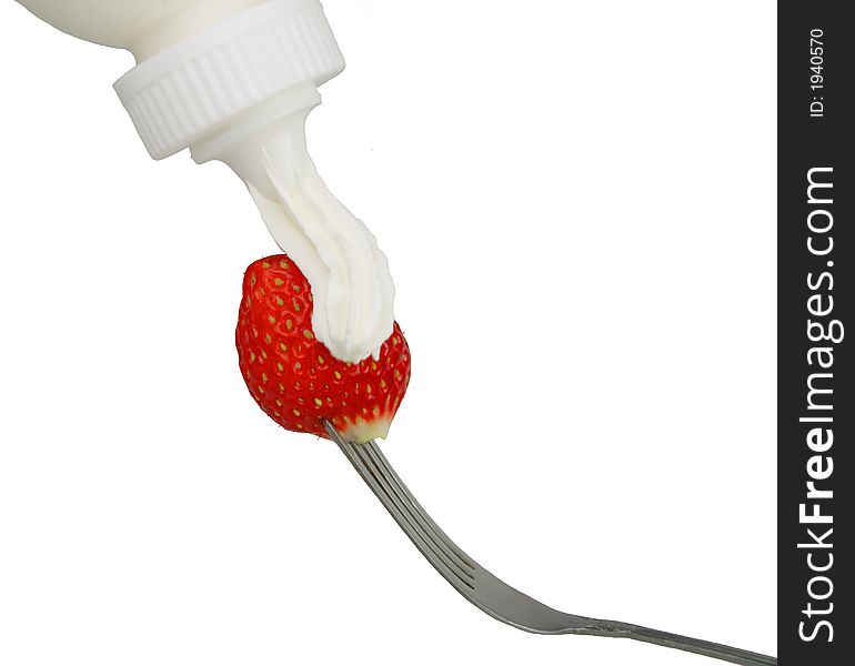 Applying whip cream on a strawberry in fork-isolated over white background. Applying whip cream on a strawberry in fork-isolated over white background.