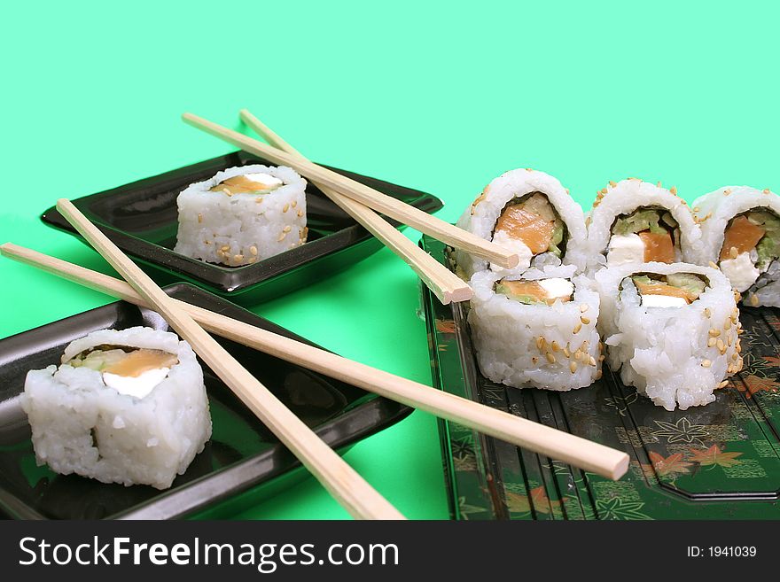 Shot of salmon sushi rolls with chopsticks