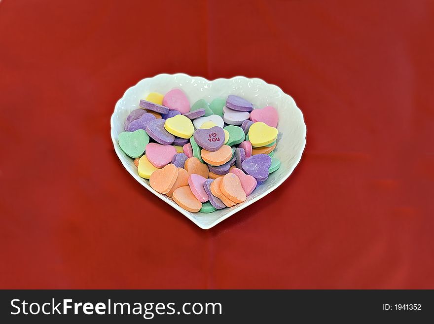 Heart shaped dish of conversation hearts.  I love you on top. Heart shaped dish of conversation hearts.  I love you on top.